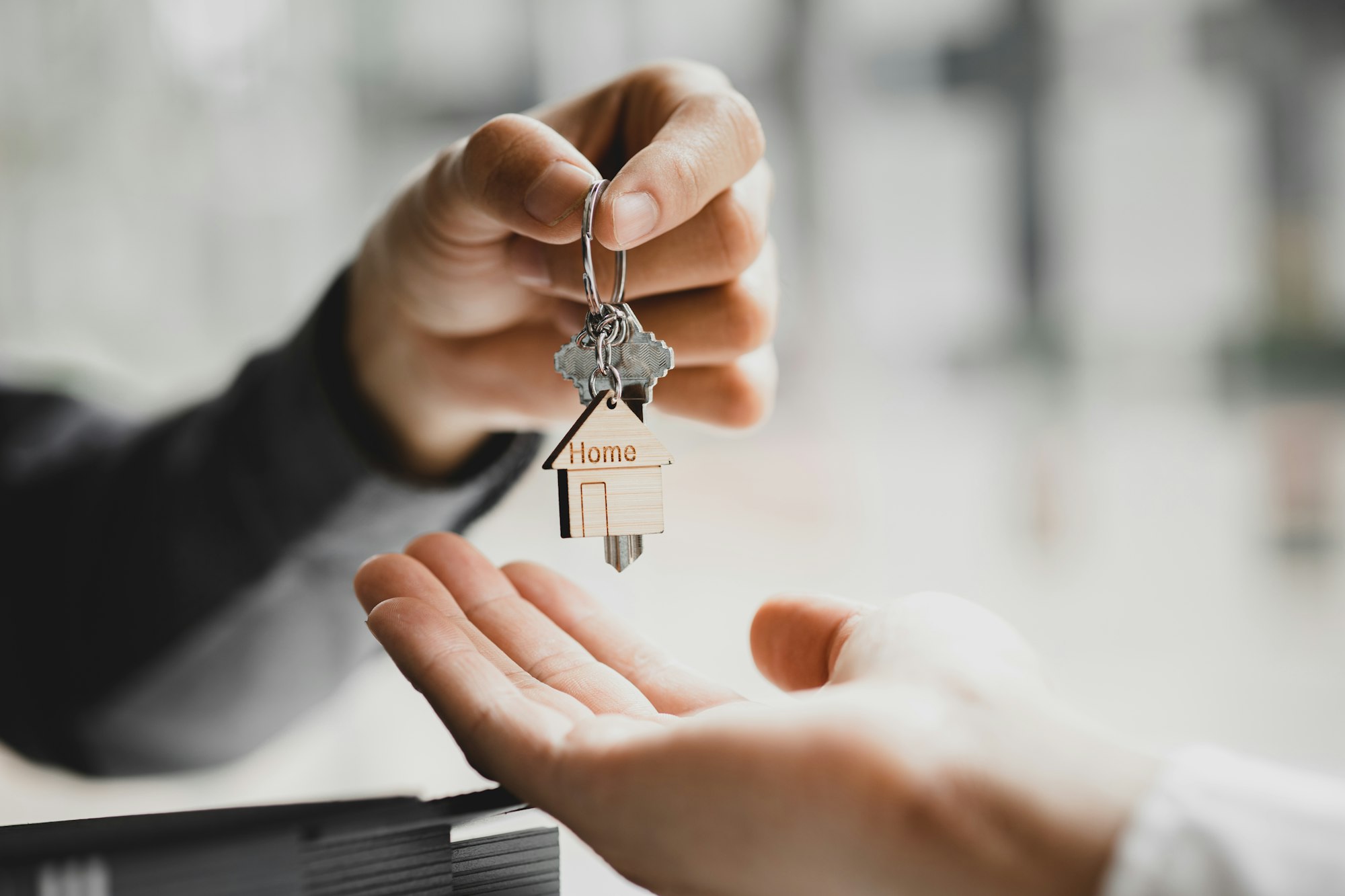 A home rental company employee is handing the house keys.