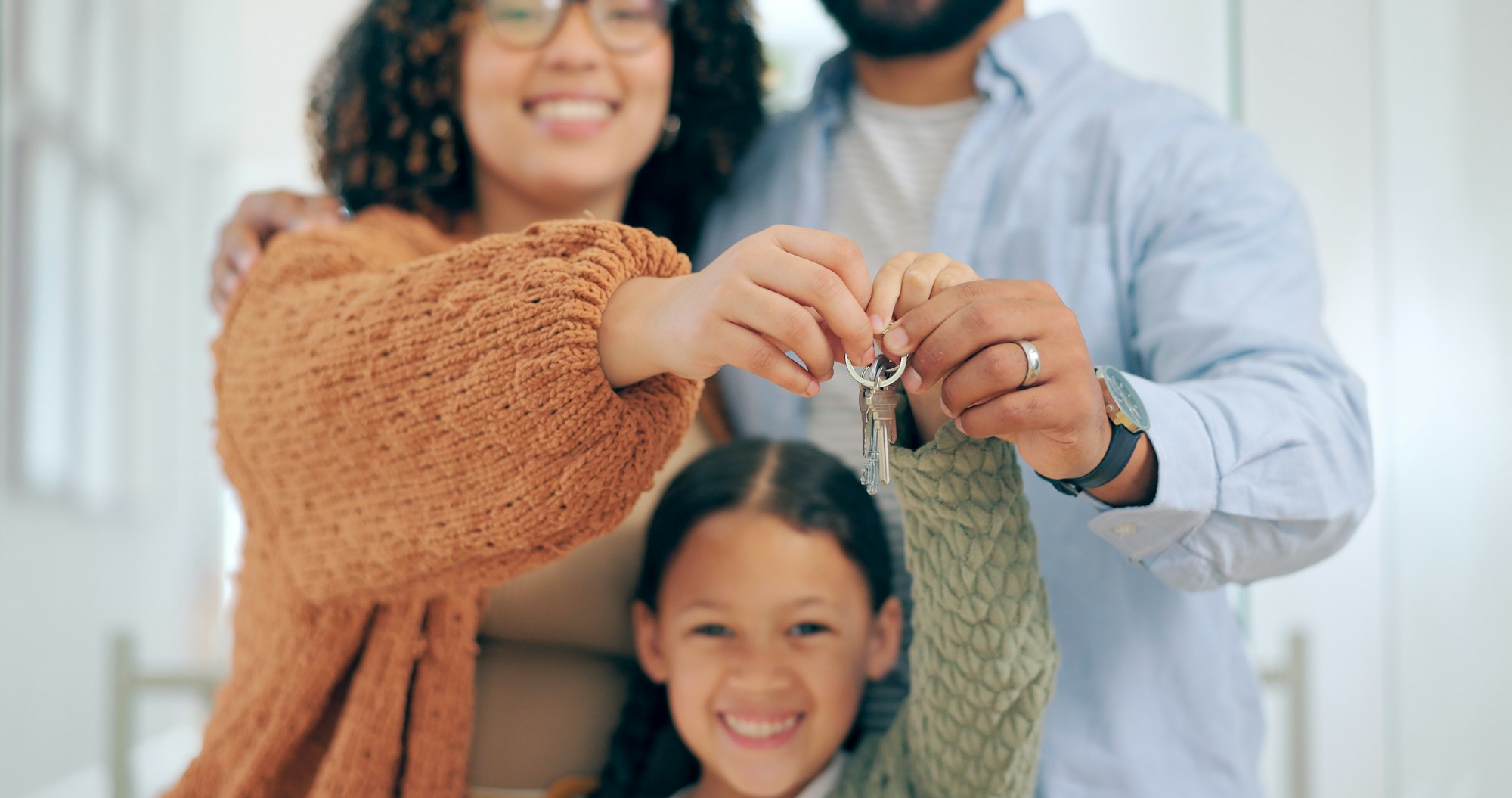 New home, keys and portrait of parents and child excited for house, property investment and moving.